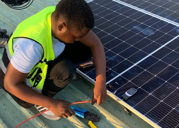 Technician working on solar panels for rural electrification